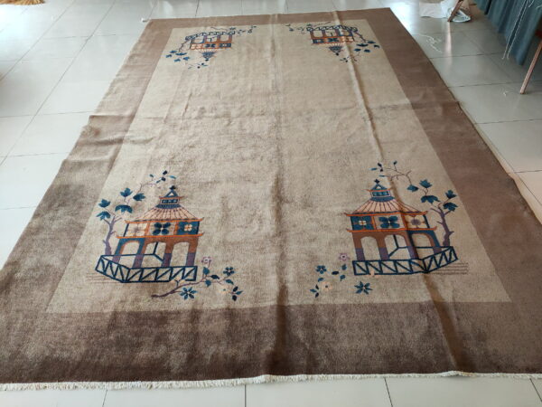 Low-pile beige rug featuring four colorful pagoda designs and vines, set on light cream square tile.