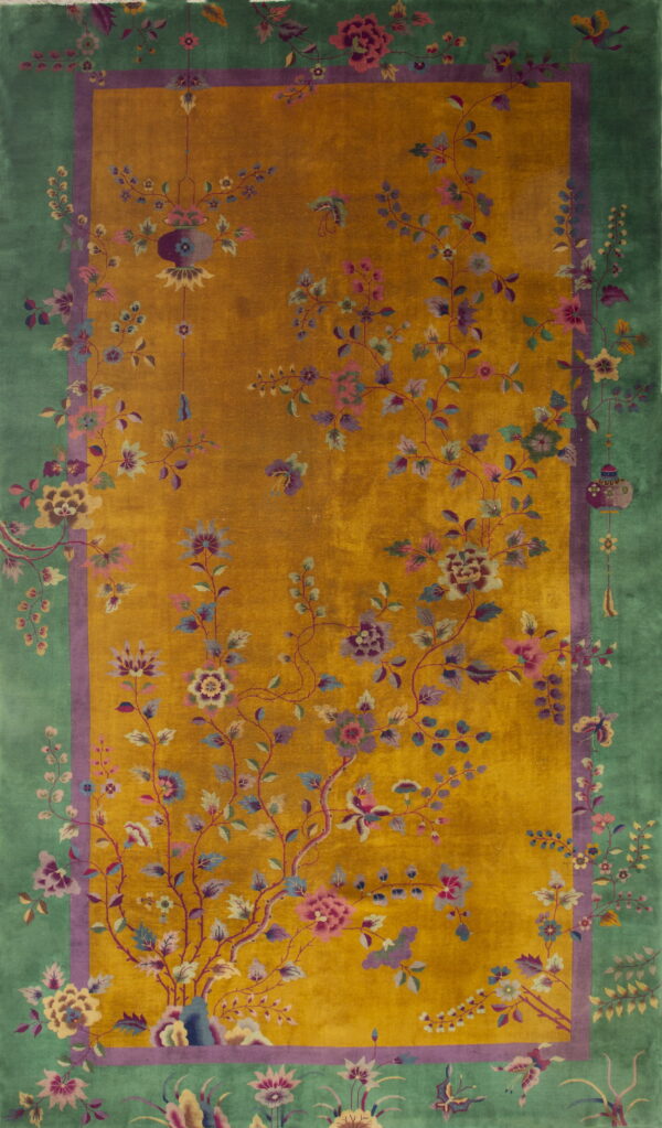 Golden yellow rug with detailed pink and purple floral vines and a wide green decorative border.
