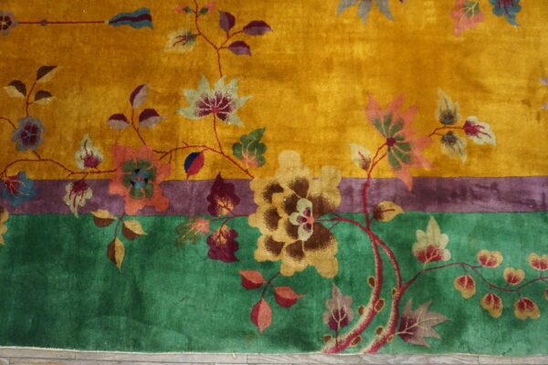 Golden yellow high-pile rug featuring a dense floral pattern with contrasting green and purple border stripes.