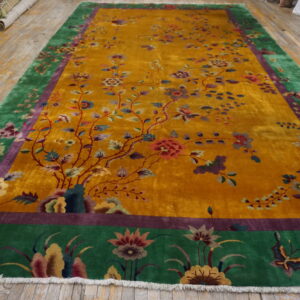 Ornate yellow rug with climbing vines and flowers, framed by wide green and purple floral borders.