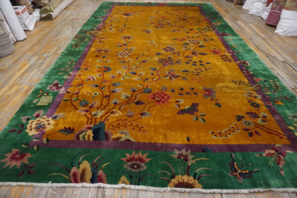 Ornate yellow rug with climbing vines and flowers, framed by wide green and purple floral borders.