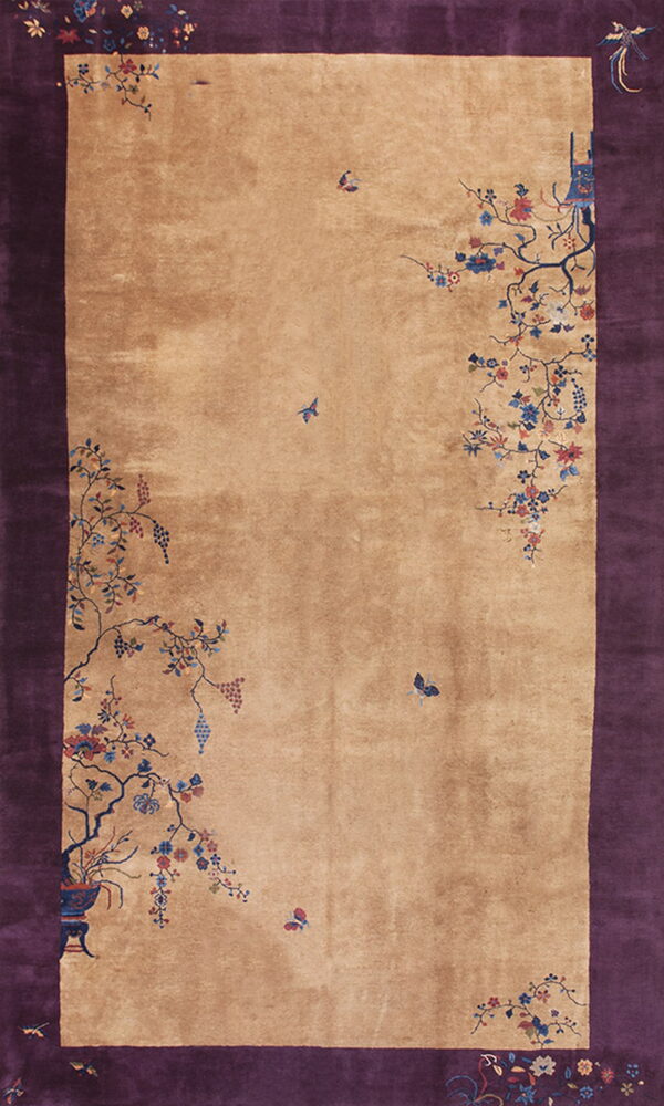 Deep purple border and tan field rug with scattered floral vines, grapes, and butterflies.