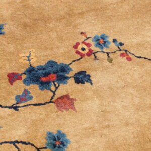 Tan rug detail shows a dark blue vine pattern with scattered blue, red, and yellow flowers.