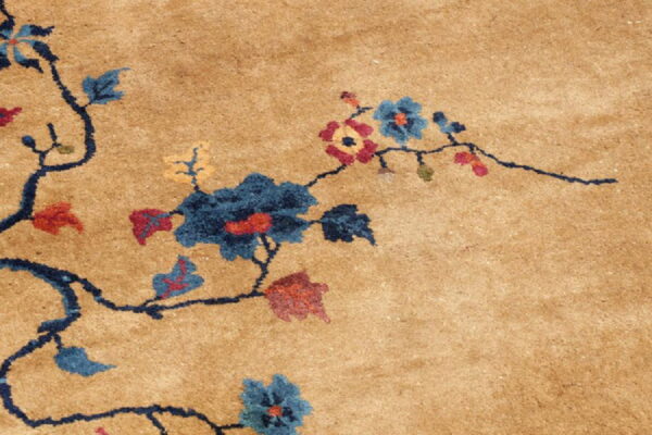Tan rug detail shows a dark blue vine pattern with scattered blue, red, and yellow flowers.