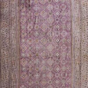 Muted purple runner rug with a low pile geometric lattice pattern and complex grey scroll borders.