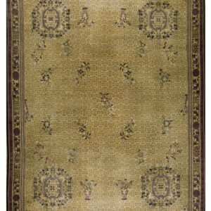 Gold rug with all-over geometric pattern, scattered purple and blue florals, and a decorative dark border.