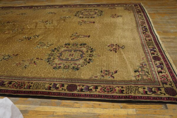 Large, tan high-pile rug with geometric and multicolor floral patterns on rustic wood floors.