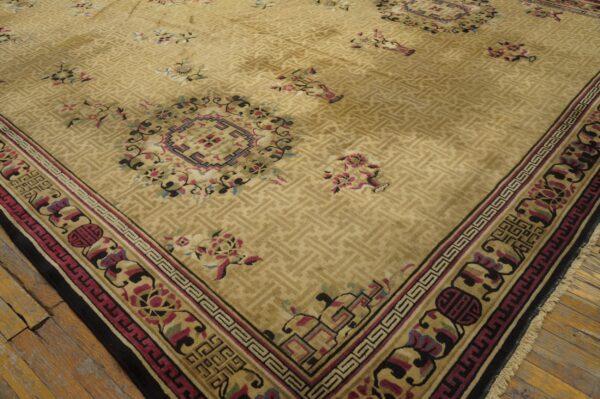 Beige rug featuring a subtle geometric field, multicolored floral accents, and layered borders on wood plank flooring.