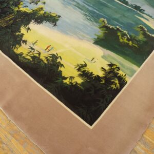 Low-pile rug with a green and yellow pictorial landscape and a wide solid beige border on wood flooring.