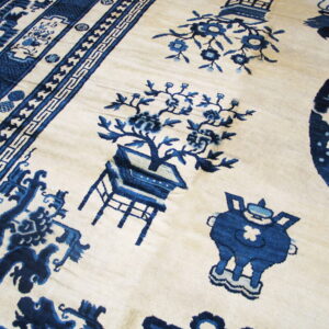 Detailed view of an ivory rug featuring complex blue traditional patterns, botanicals, and multiple ornate borders.