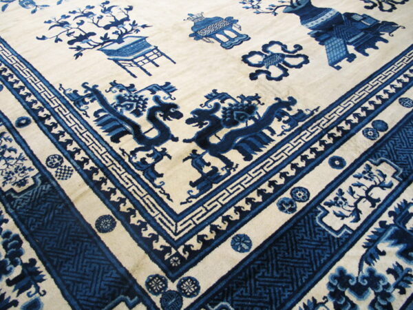 Cream and blue rug featuring a detailed corner with stylized dragons and a variety of geometric borders.
