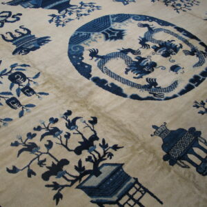 High-pile rug showing a cream background and detailed dark blue dragon, floral, and vessel motifs.