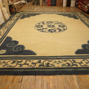 Square cream rug with blue cloud motifs and a medallion displayed on distressed wood flooring.