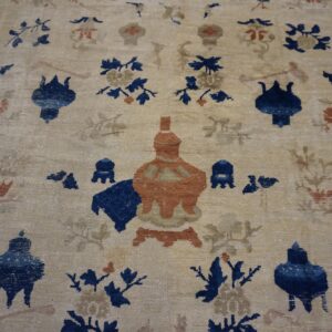 Light tan rug with blue and rust stylized vessels and botanicals, framed by a dark blue geometric border.