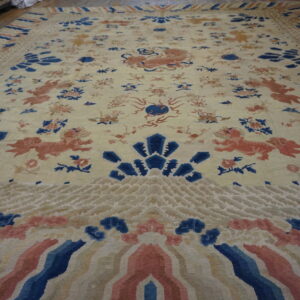Cream rug featuring coral animal figures, blue floral designs, and wide patterned borders on wood flooring.