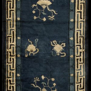 Deep blue runner rug with scattered cream motifs and a wide geometric key border in cream, black, and teal.