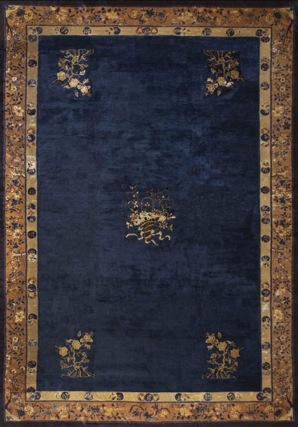 Navy blue rug with scattered gold floral elements and intricate tan and dark blue patterned borders.