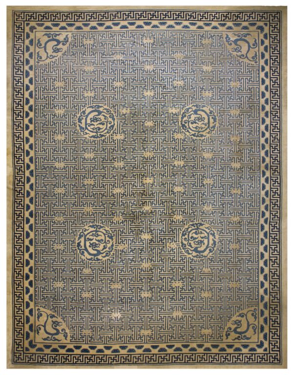 A rectangular blue and beige rug with a dense geometric fret pattern and circular dragon motifs.