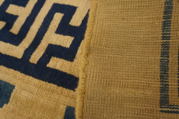 High-pile tan and navy greek key pattern meets a tight woven tan backing with thin blue stripes.