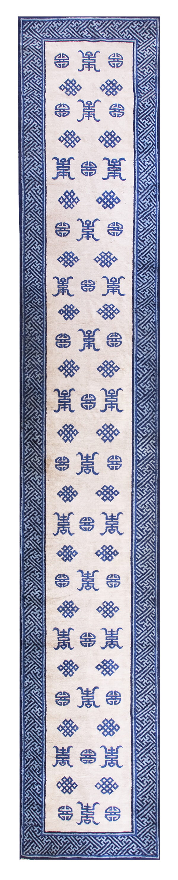 Off-white runner rug with dark blue stylized symbols and a thick blue interlocking geometric border design.