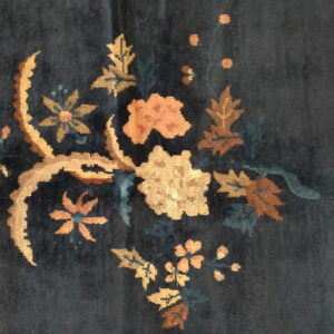Deep blue rug featuring a vibrant gold, rust, and peach floral and leaf spray pattern.