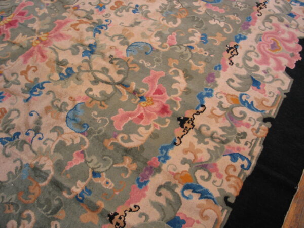 High-pile rug featuring scrolling floral patterns in pink, blue, orange, and green on a pale beige field.