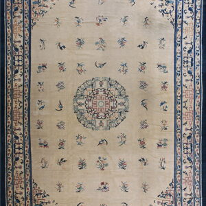 Beige rug with deep blue border and scattered floral motifs surrounding a large central medallion.