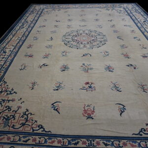 Beige rug featuring a central medallion and scattered motifs surrounded by an ornate blue and red border.
