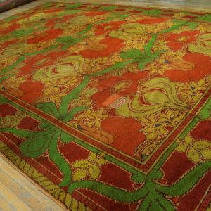 Bold, high-pile rug with red, bright green, and yellow floral patterns rests on worn wooden floorboards.