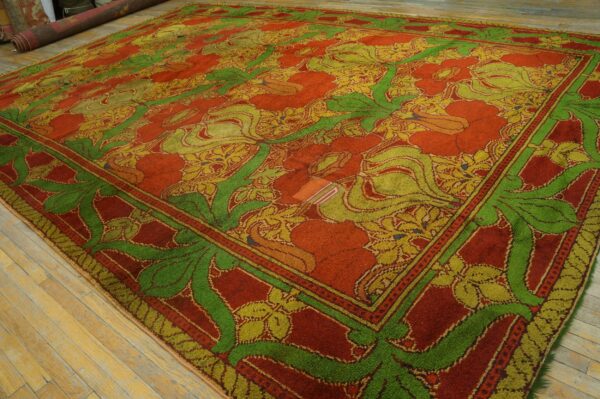 Bold, high-pile rug with red, bright green, and yellow floral patterns rests on worn wooden floorboards.