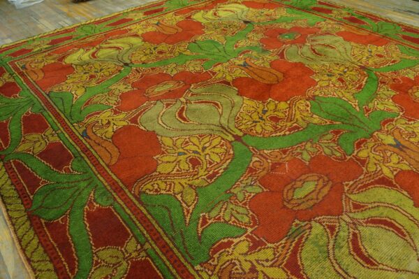 Stylized floral rug featuring large leaves and blossoms in red, green, and gold on a plank floor.