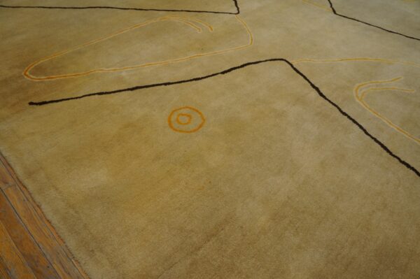 Vintage large size modernist mid century modern ecuadorian art rug 4 Muted yellow rug with dark geometric lines and flowing orange accents rests on distressed wood flooring.