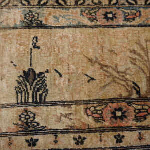 Muted tan rug detail featuring stylized scenic motifs and intricate borders with peach, blue, and black accents.