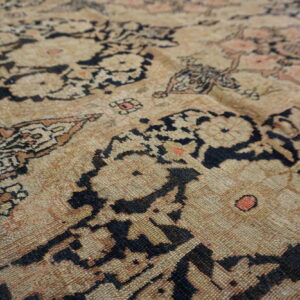 Distressed low-pile rug texture featuring an intricate pattern in beige, black, and subtle coral.