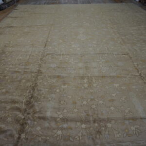 Expansive low-pile taupe rug displays a subtle cream floral pattern on wood plank flooring.