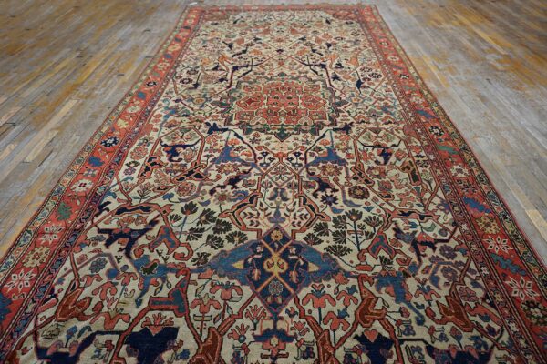 Low-pile area rug featuring an ornate medallion design in rust, navy, and cream on worn wooden floors.