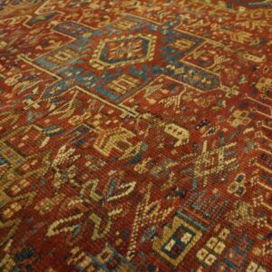 Dense geometric patterns visible on a rug in rust red, teal, and gold tones.
