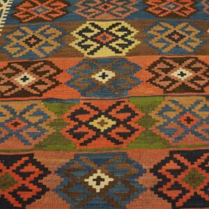 Multicolor flatweave rug displaying geometric medallions arranged in horizontal stripes on a wood floor.