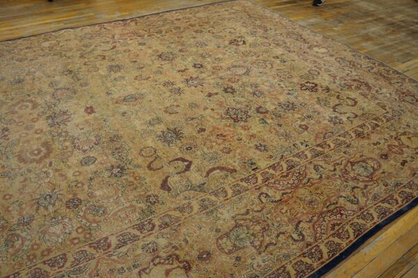 Distressed, low-pile rug with beige and faded burgundy floral motifs lying on rustic wooden planks.