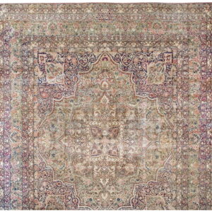 Faded traditional rug with a large central medallion and detailed borders in pale pink, blue, and beige.