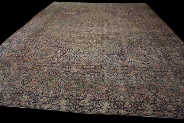 Traditional large area rug in faded pink, navy, and cream with complex floral medallion design.