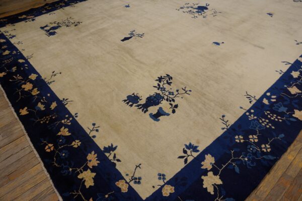 Cream rug with scattered blue floral patterns and a dark blue border featuring tan blossoms on wood planks.