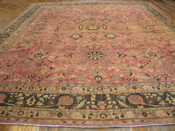 Large low-pile rug with a rose field and intricate blue and beige floral patterns on wooden planks.
