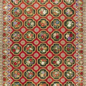 Ornate red rug featuring a repeating pattern of dark green quatrefoil medallions filled with multicolored flowers.