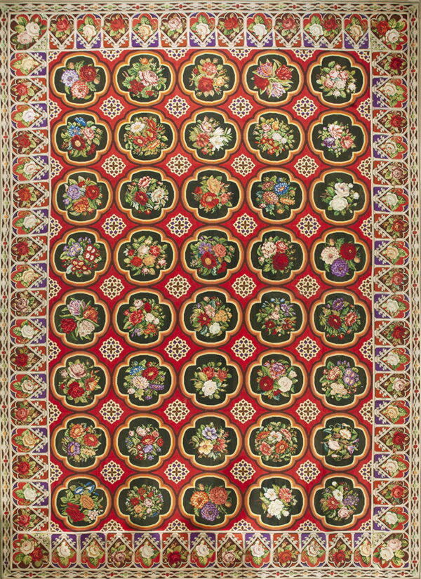 Ornate red rug featuring a repeating pattern of dark green quatrefoil medallions filled with multicolored flowers.