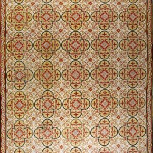 Repeating geometric and floral rug pattern featuring red, gold, cream, and olive green colors.