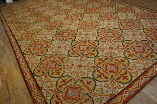 Intricate, large area rug with repeating red, olive, and cream floral medallions on wooden plank floors.