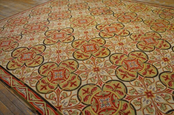 Low-pile rug with interlocking quatrefoil patterns in red, green, yellow, and cream on distressed wood flooring.