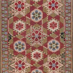 A detailed textile with red, cream, green, and blue geometric patterns featuring hexagonal star motifs.