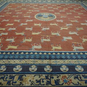 Red rug with repeating yellow animal motifs, a central round bird design, and multi-layered blue borders.